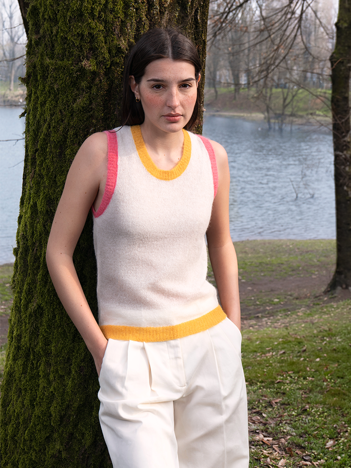 Person wearing a sleeveless top with colorful trim in a park setting