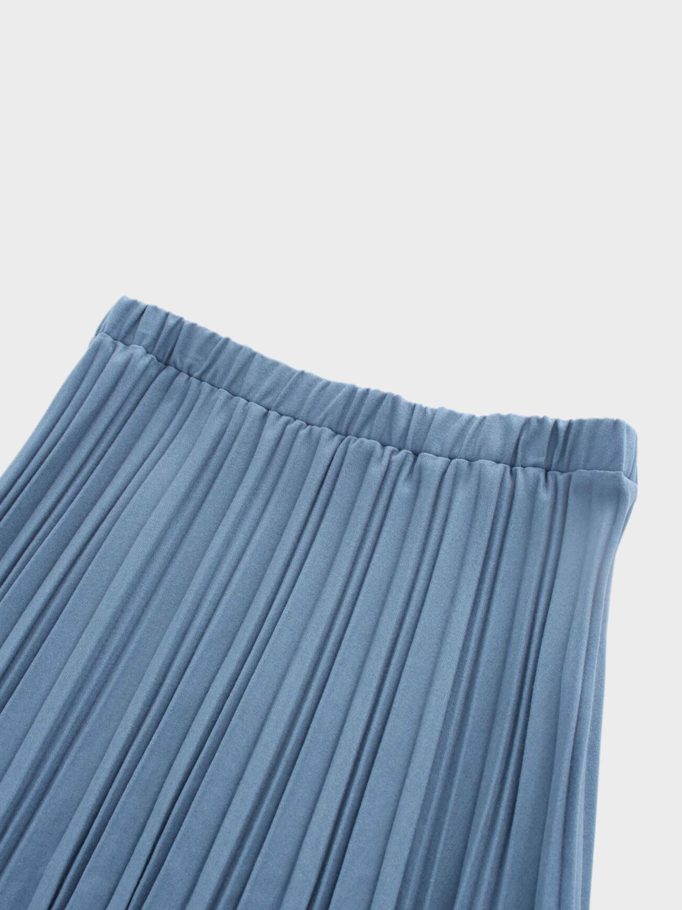 Close-up of pleated blue fabric on a light gray background