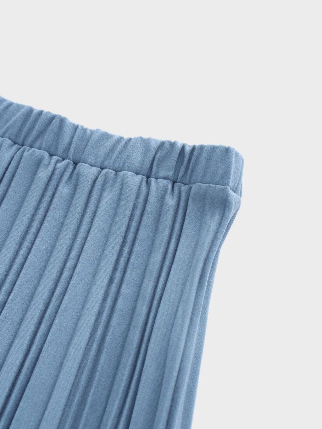 Close-up of blue pleated fabric on a light gray background