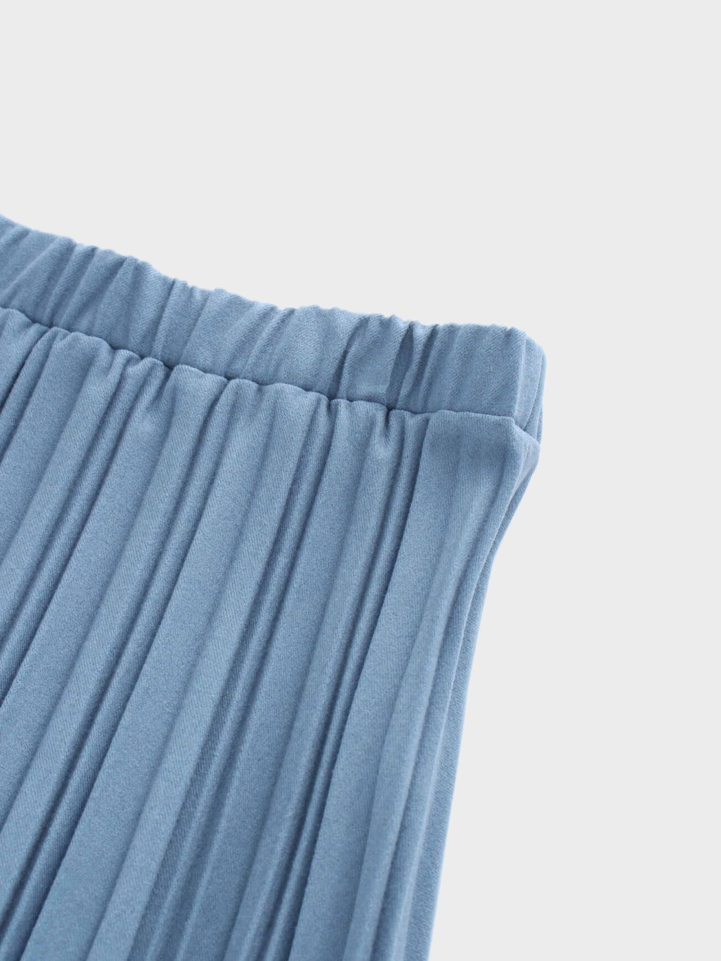 Close-up of blue pleated fabric on a light gray background