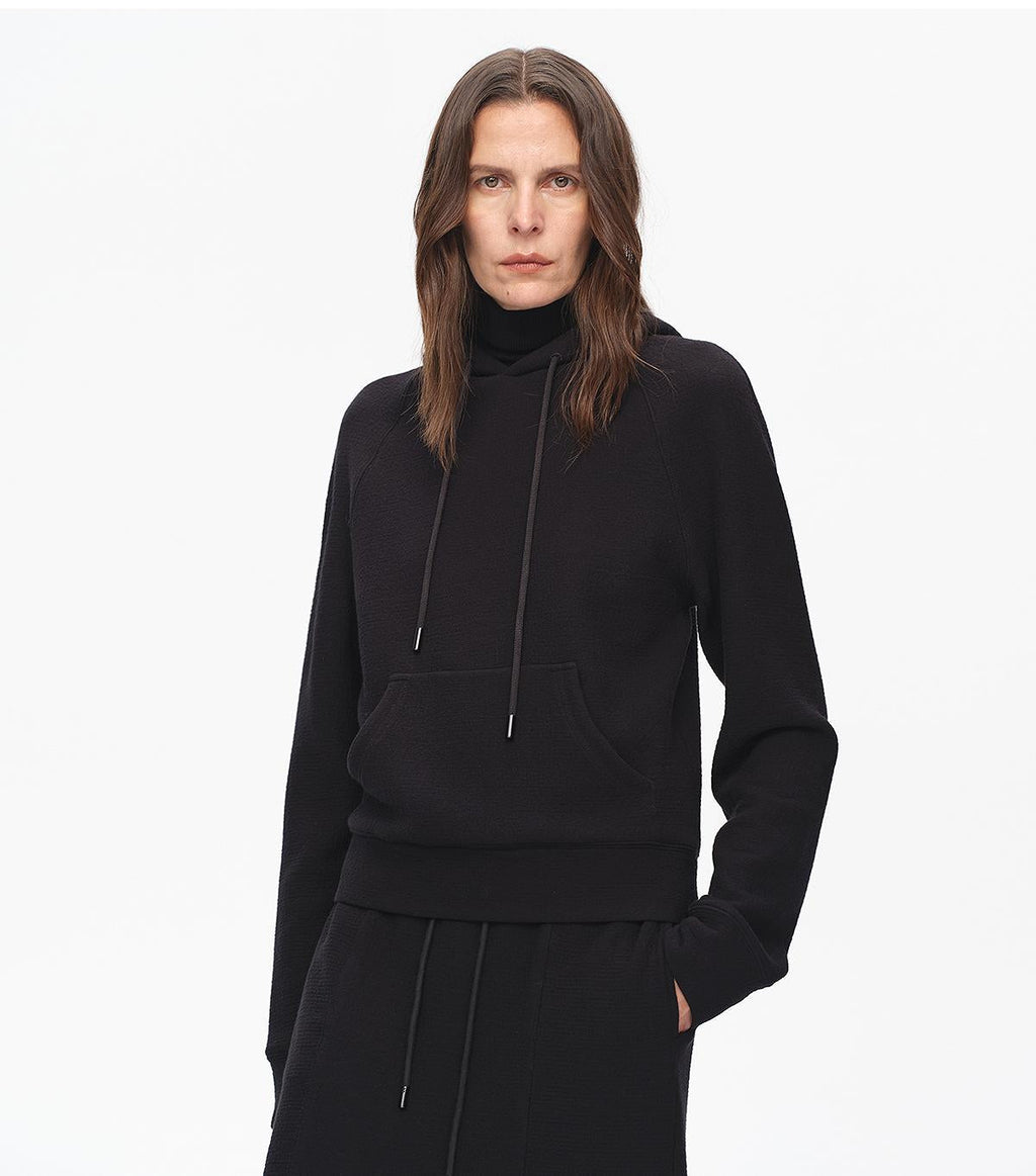 Person wearing a black hoodie on a white background