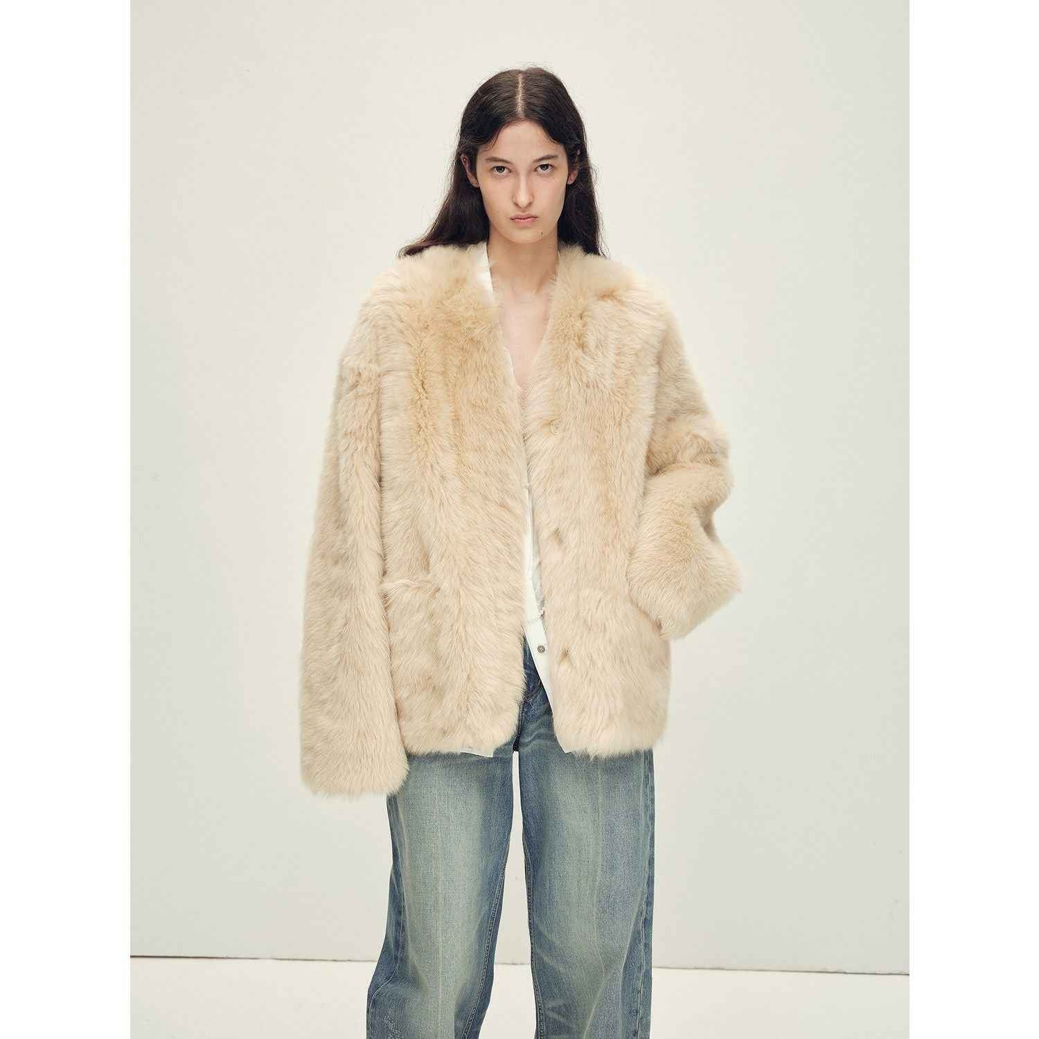 Person wearing a cream fur coat and jeans on a white background