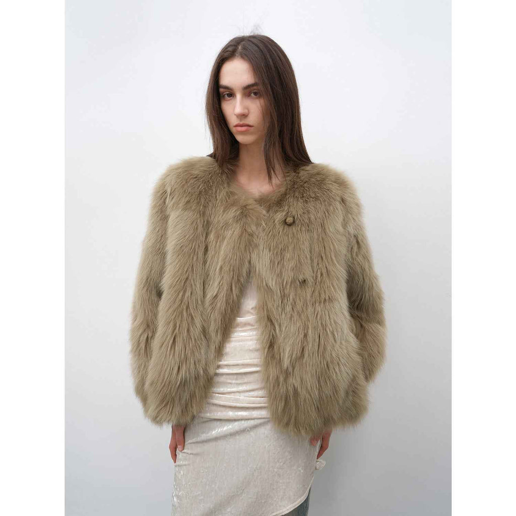 Woman wearing a fluffy beige jacket against a white background