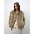 Woman wearing a fluffy beige jacket against a white background
