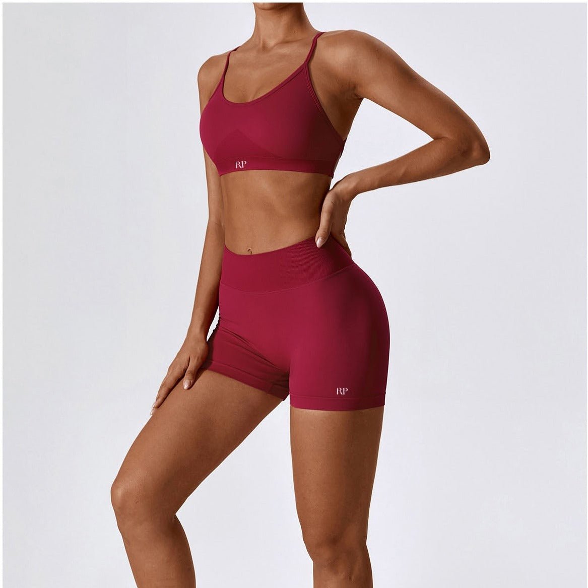 Maroon sports bra and shorts set on a plain background