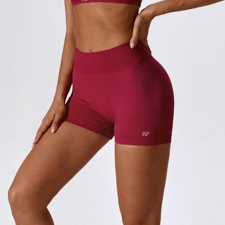 Maroon athletic shorts worn by a person on a white background