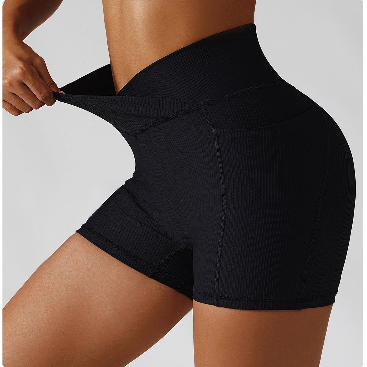 Person wearing black athletic shorts on a plain background