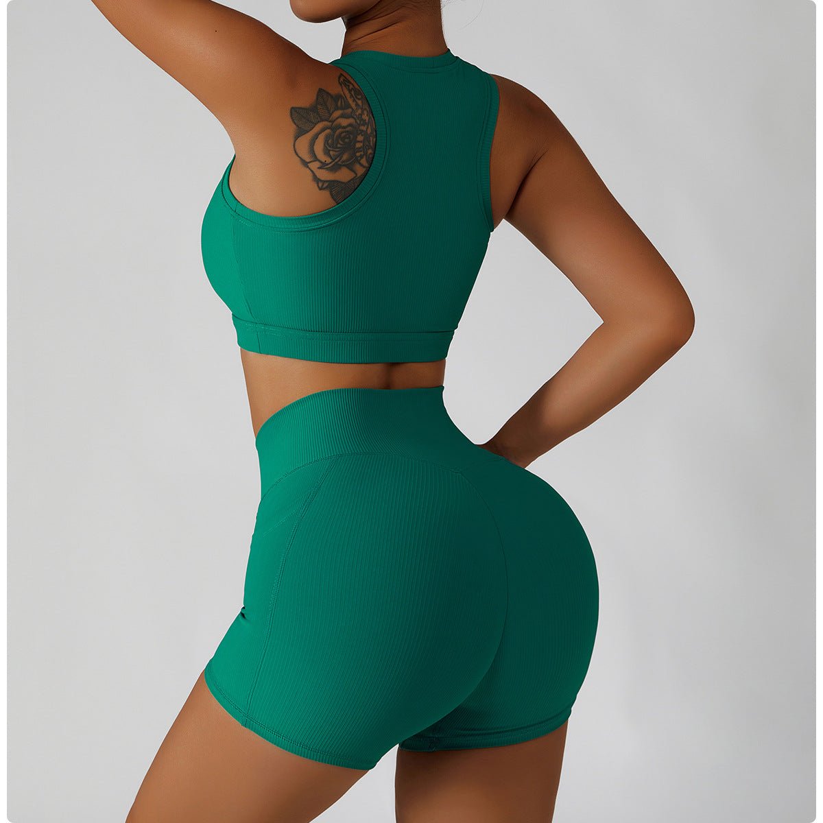 Person wearing a green sports bra and shorts set on a plain background