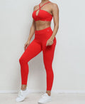 Person wearing a red sports bra and leggings set with white sneakers on a light background
